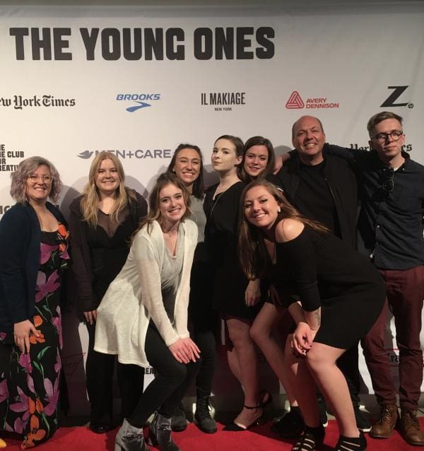 Photo of a group of CCS Advertising Design students smiling and posing on a red carpet.