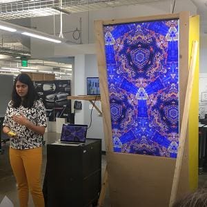 Woman giving presentation on projected design controlled by computer