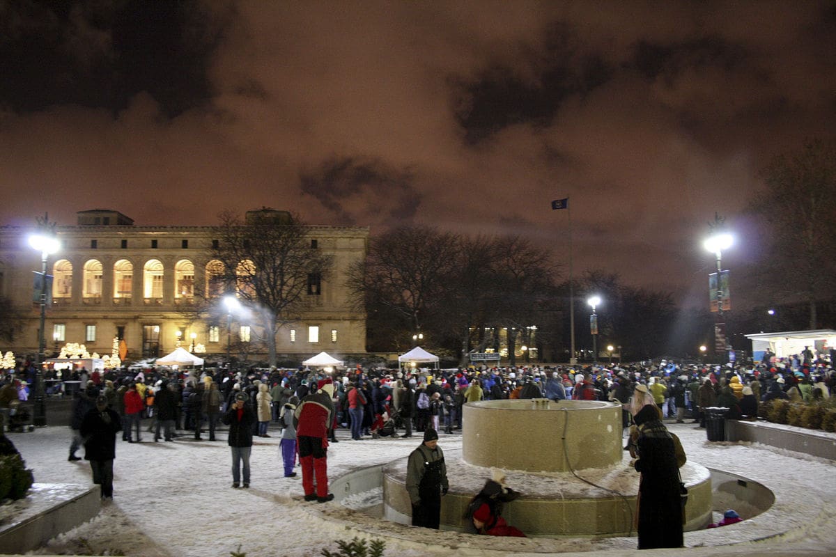 Photo of a crowd outside the Detroit Institute of art on a cloudy. snowy winter night.