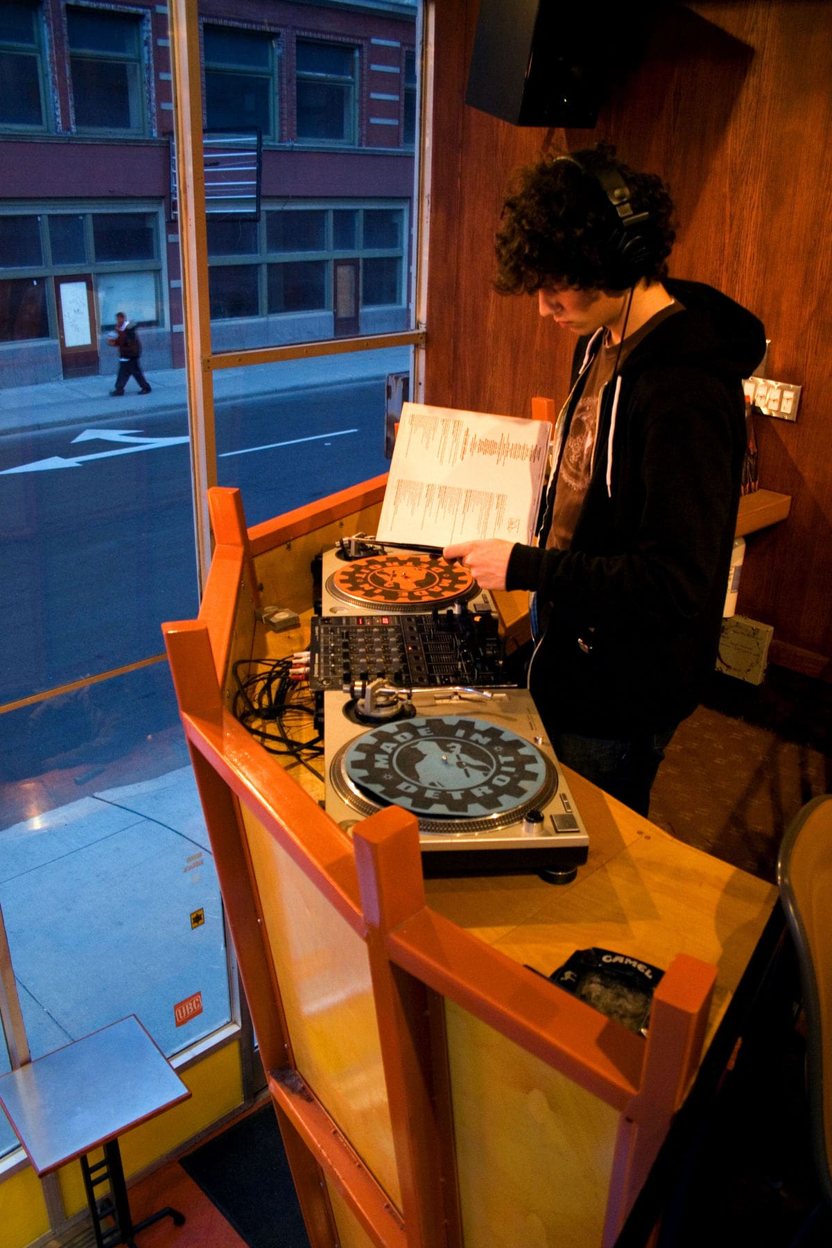 Photo of a dj playing on some turntables in a club in Detroit.