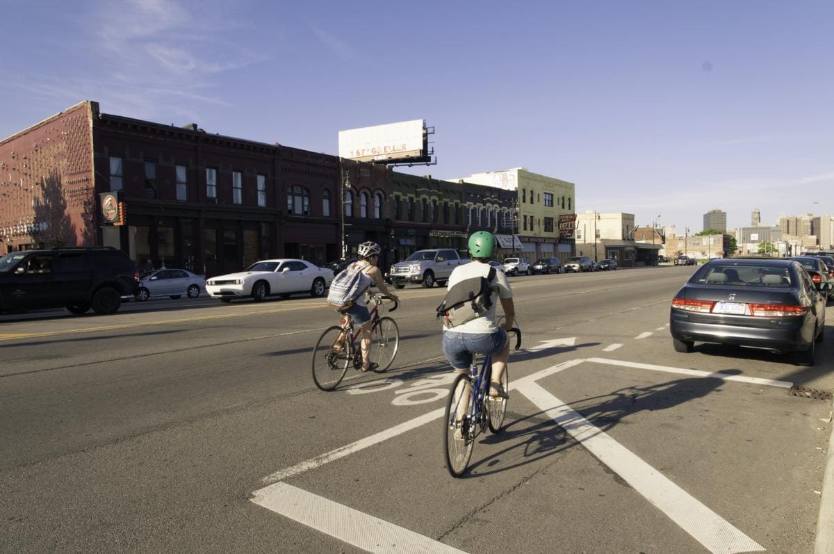 Photo of two bikers driving down the road in Detroit.