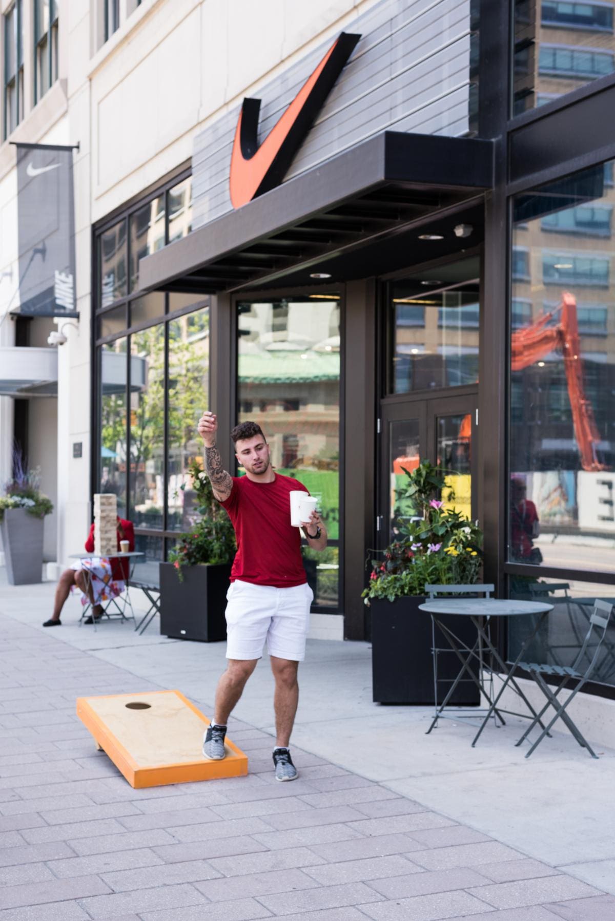 Photo of a man playing cornhole outside a Nike store in Detroit.