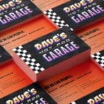 \Digital rendering of the front side and backside of a business card, arranged in a checkerboard pattern. The back is all orange with black text. the front is black with one stripe of black and white checkerboard. There is white, pink, and yellow grafiti-like text that says "Dave's Hot Rod Garage".
