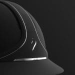 Closeup photo of a black concept horseback riding helmet on a black background.