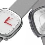 A front and back view of a concept wrist watch with a white clock face, silver hardware, and red arms.