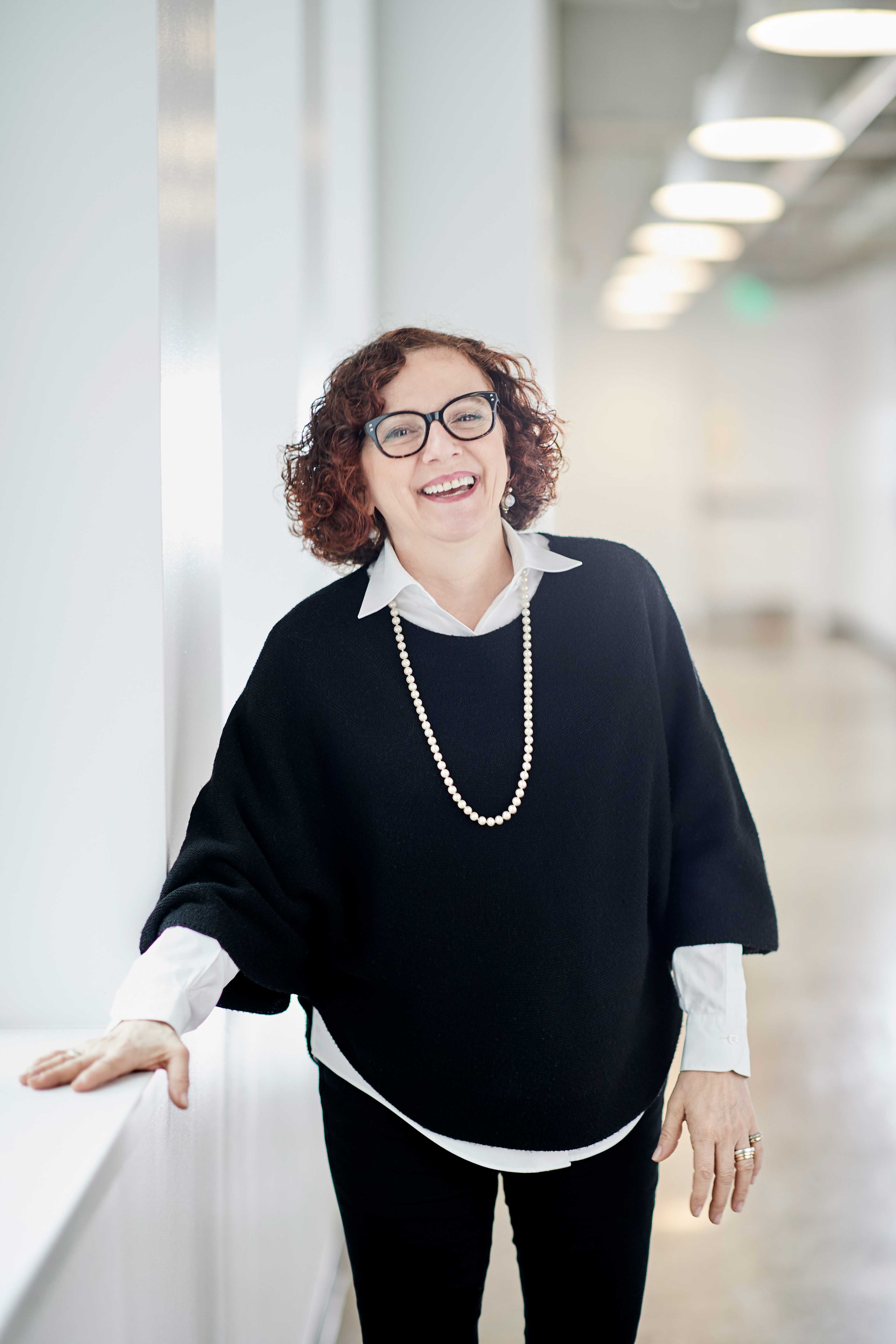 Portrait photo of Maria Luisa Rossi smiling in a hallway