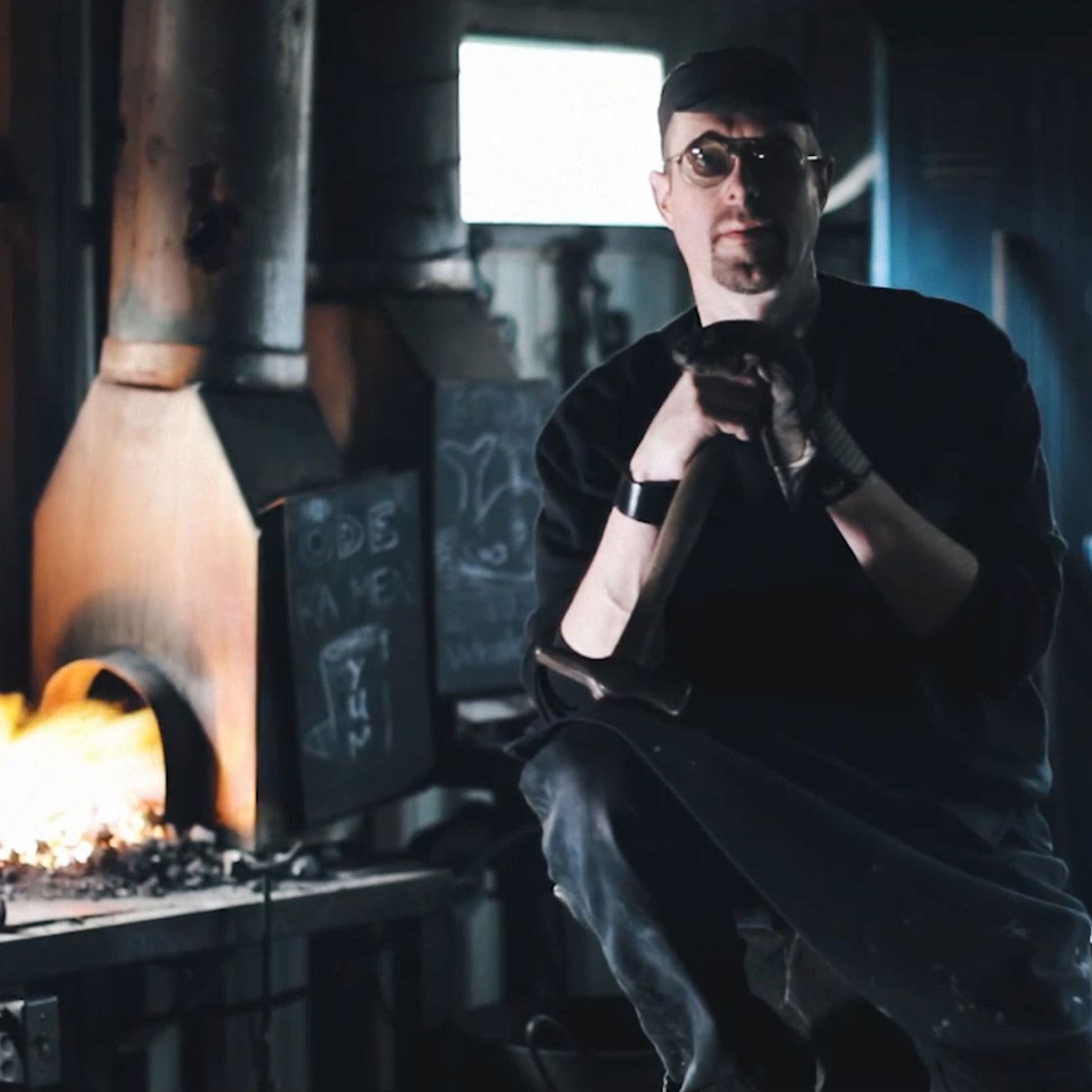 Headshot of a man sitting in a glassblowing studio