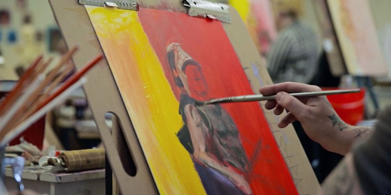 Closeup photo of someone painting a gladiator on an easel