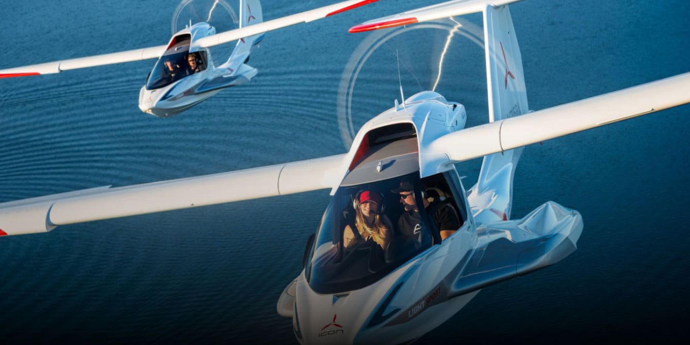 Digital rendering of two small white concept planes flying over the ocean.