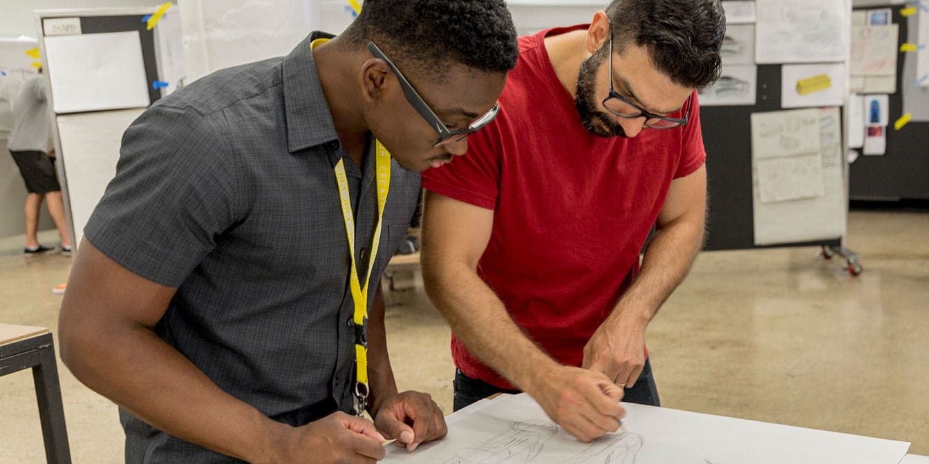 Photo of two men designing a project at a work table.