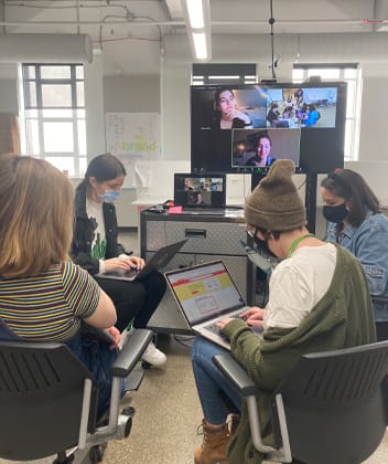 students gathered around a zoom screen collaborating