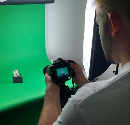 student photographing work with a green screen