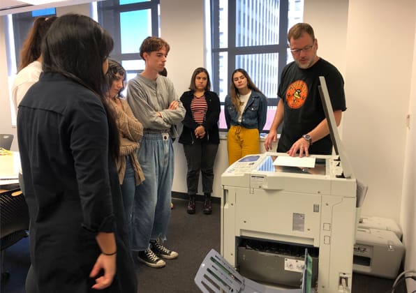 Students gathered around a Riso printer