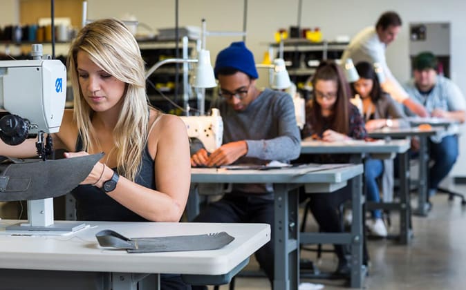 students sewing on sewing machines in the studio