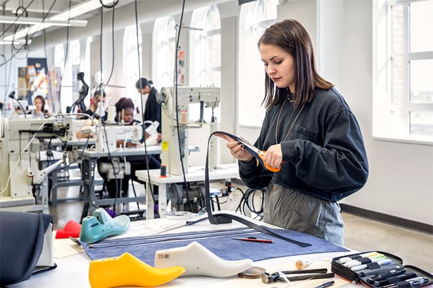 a student cutting patterns at a work table