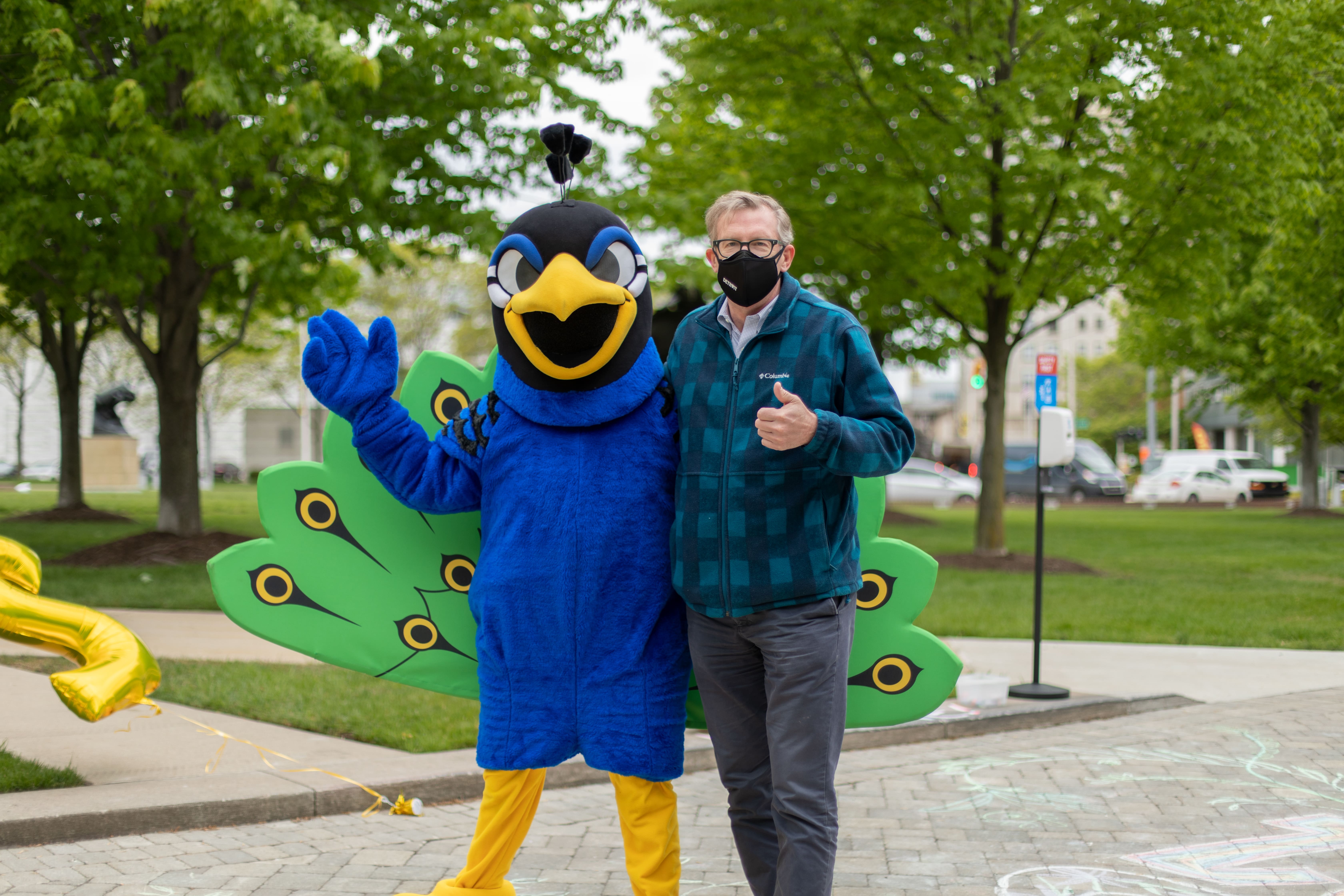 Photo of President Don Tuski with the Watson peacock mascot