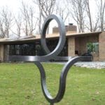 An abstract shaped metal sculpture exhibited outdoors