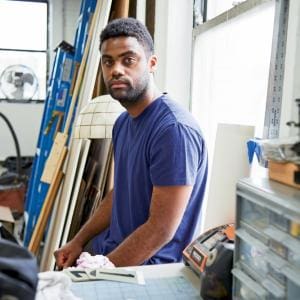 A profile photograph of alumni Kevin Beasley in an arts studio.
