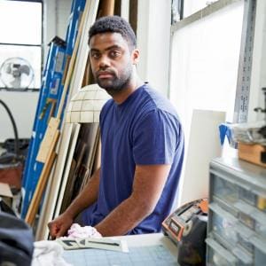 A profile photograph of alumni Kevin Beasley in an arts studio.