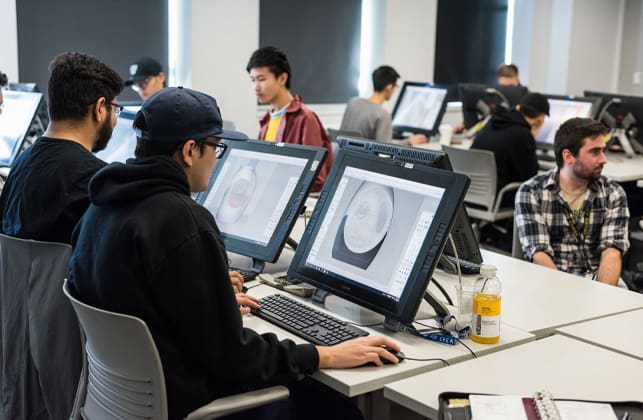 A photograph of a person drafting a design on a large computer screen