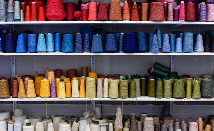 A photograph of colored spools of thread in the fashion studio