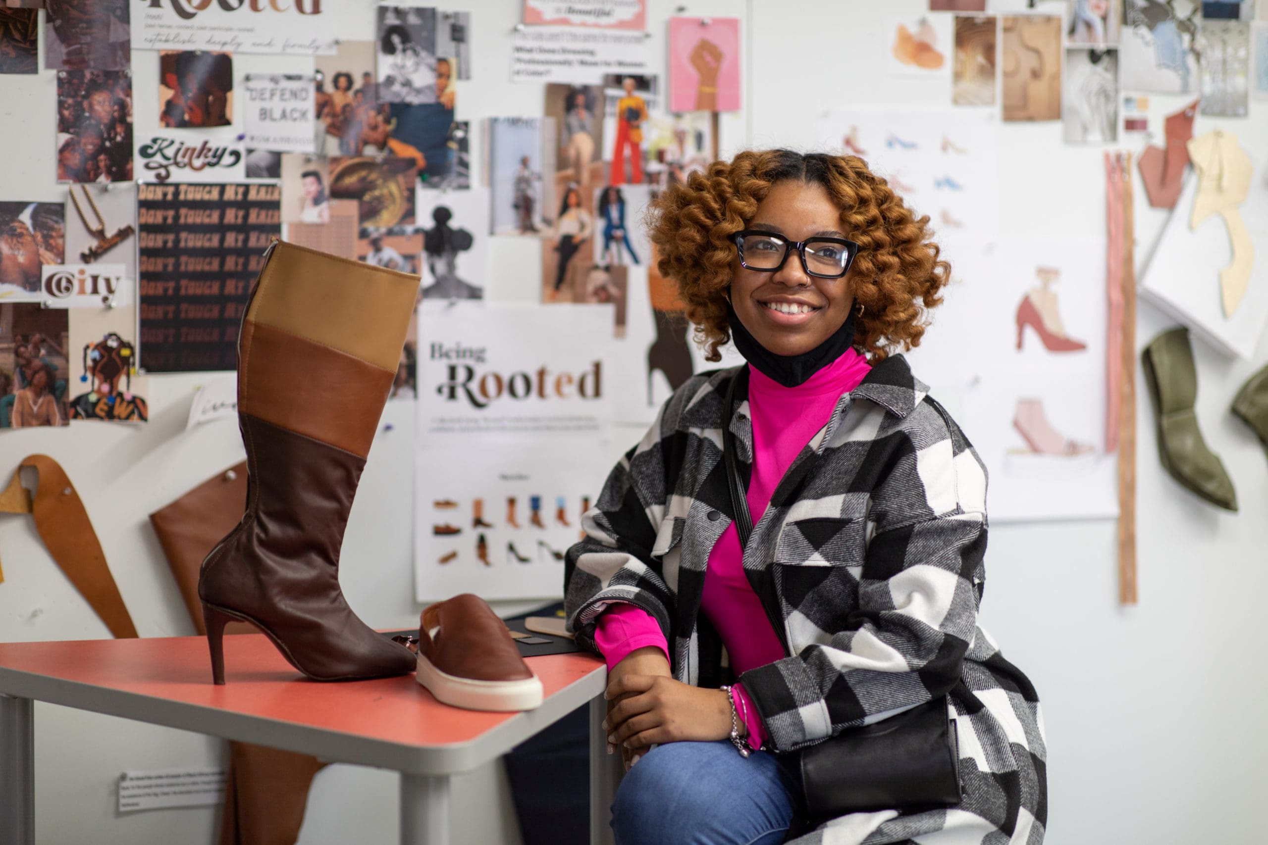 A student poses with her boot for the Stuart Weitzman Project