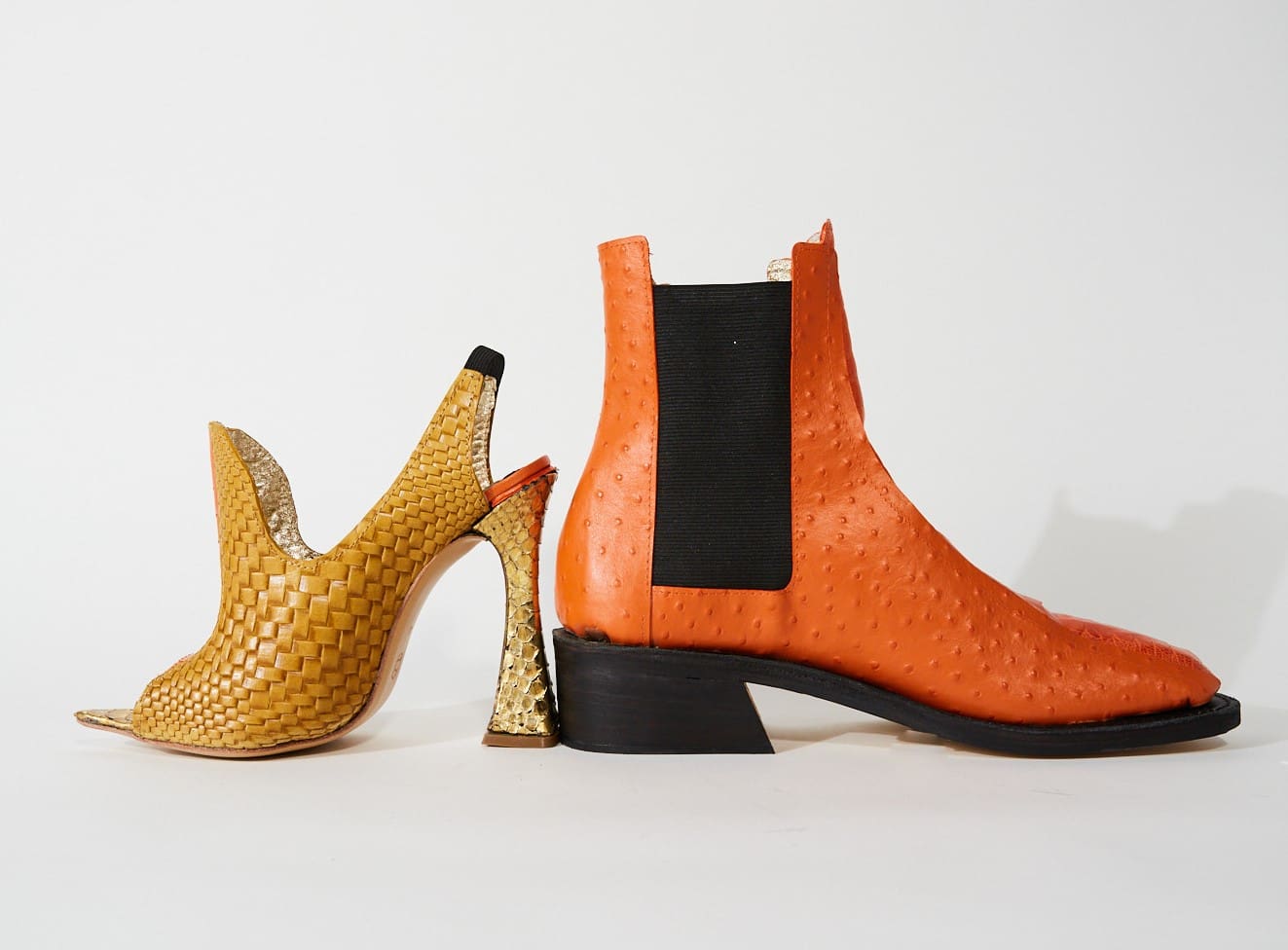 Two artistic fashion shoes pictured against a white background. The left high heel is yellow with a weft pattern, and a complex cut-out around the ankle. The right high heeled boot is orange with a dotted pattern with a rectangular mesh cut-out at the ankle.