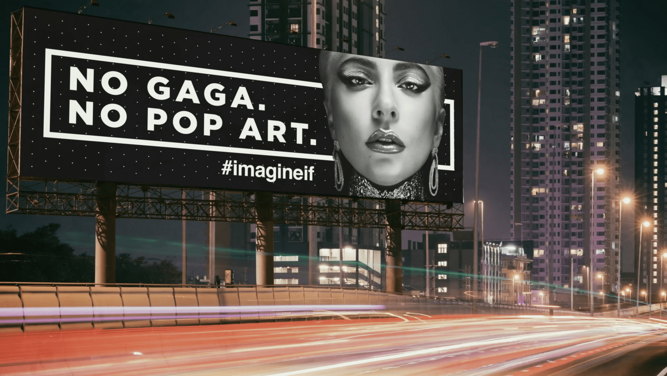 Image of a billboard on the side of a city highway at night. The billboard has a black and white image of Lady Gaga against a black background. To her right are the words "No Gaga. No Pop Art. #Imagine If" in bold white text.