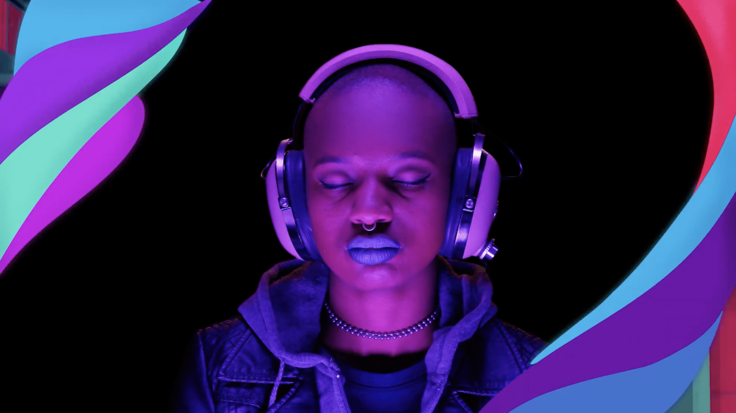 An advertisement that depicts a photo of a woman from the shoulders up against a black background, lit with purple lighting. The woman has her eyes closed and is wearing headphones, a jean jacket over a sweatshirt, bold blue lipstick, and winged eyeliner. She is framed by abstract green, pink, purple, blue, and red swirls.