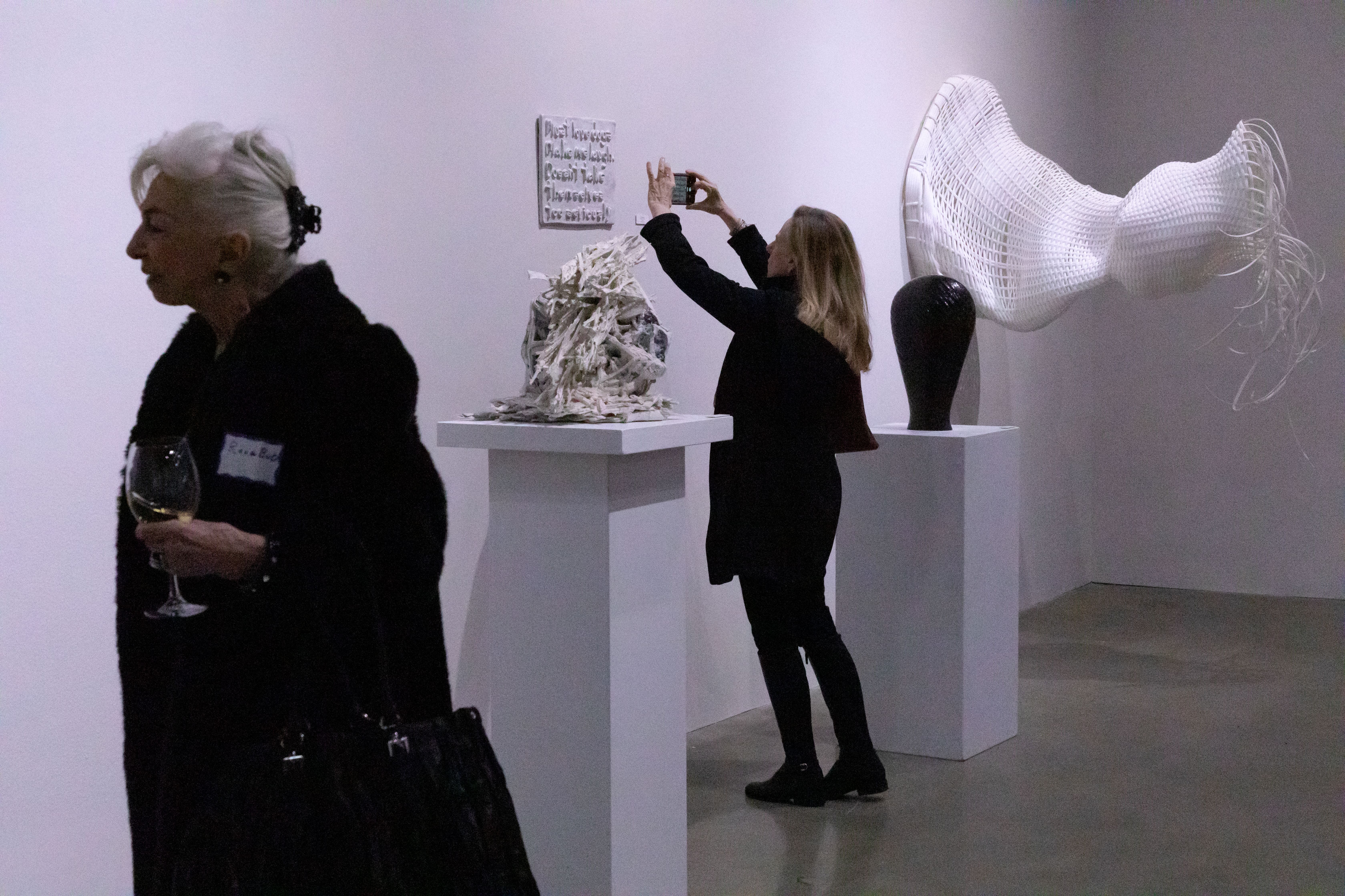 various masked individuals viewing art in a gallery