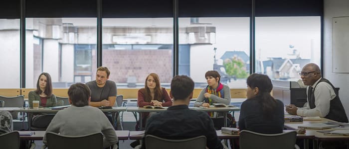 students sitting in a classroom discussing at tables