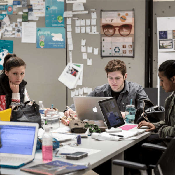 students sitting at a table with laptops