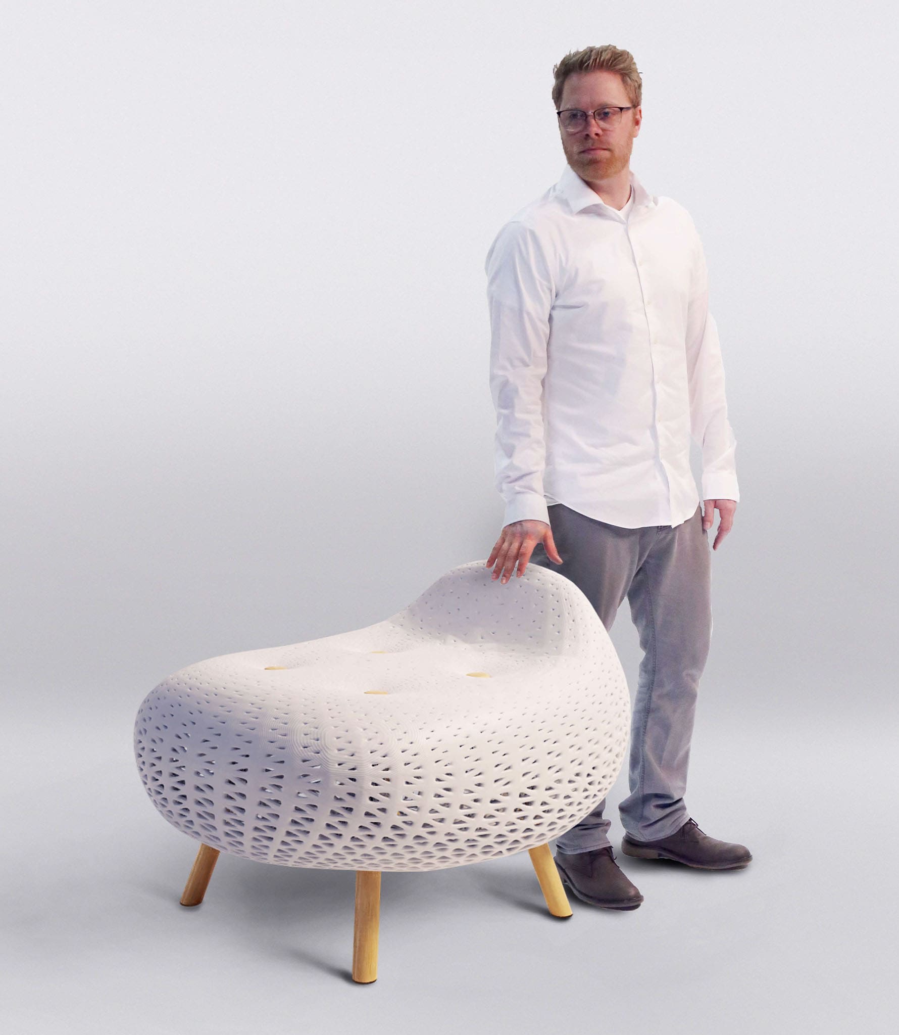 A product design major standing next to a white fancy ottoman