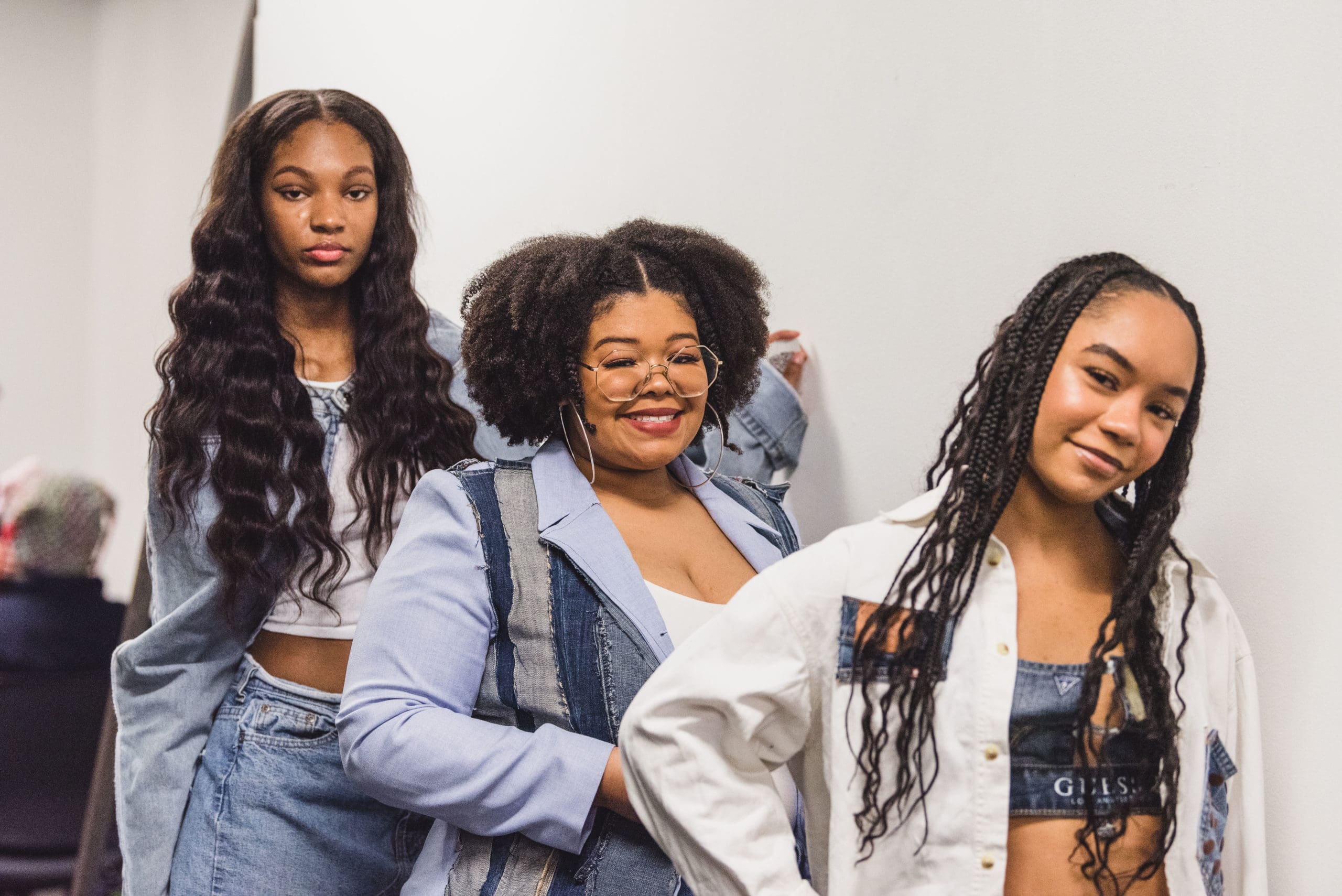 three CCS fashion student models made up and adorned in newly created denim fashions