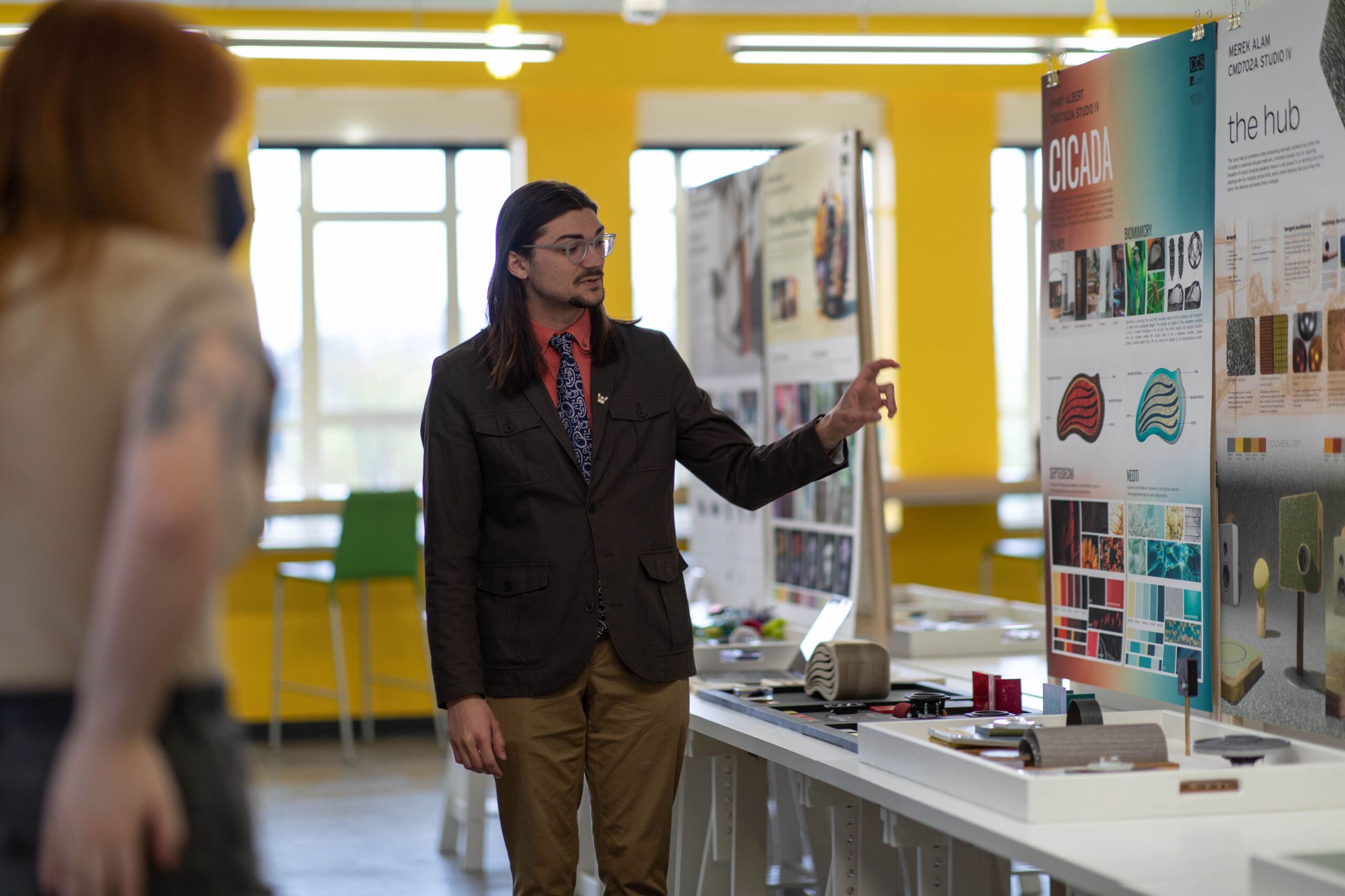 A Color and Materials Design graduate student presenting a red and blue board of materials.