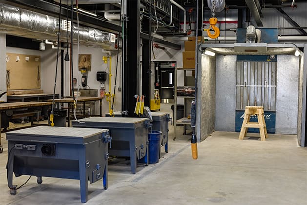 Full view of the sculpture studio including tables, a dust booth and ventillation