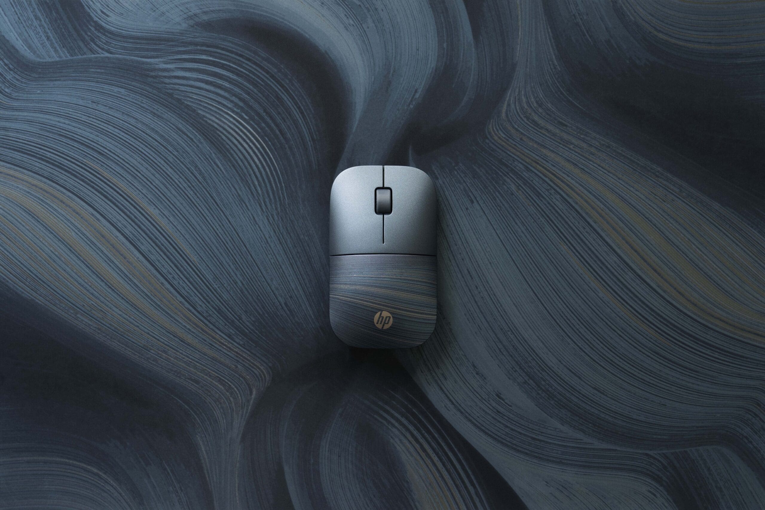 Photo of a grey computer mouse on a grey swirled background