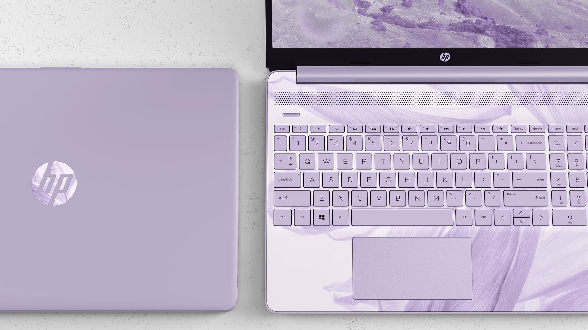 Photo of a lavender colored laptop with a marbled keyboard.