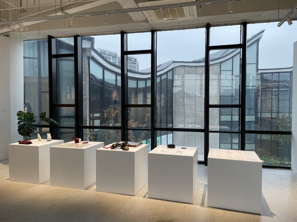 alumni work and projects featured on white pedestals at the alumni reception in Shanghai