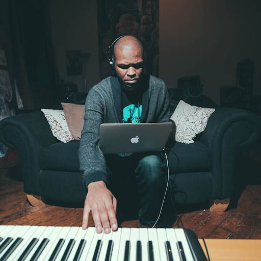 Stirling Toles 2 stirling toles working a keyboard and laptop on a navy blue couch