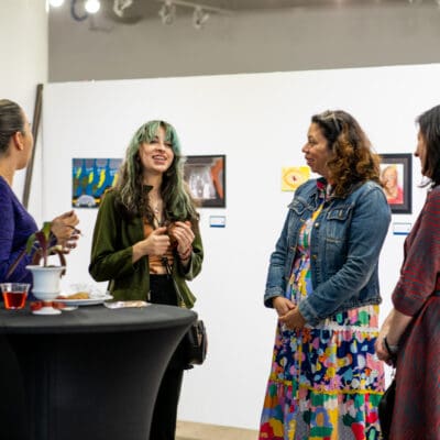 People mingle at the CAP directors choice exhibition with artwork in the background