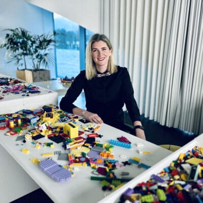 Megan Shellenbarger sitting at a desk full of lego