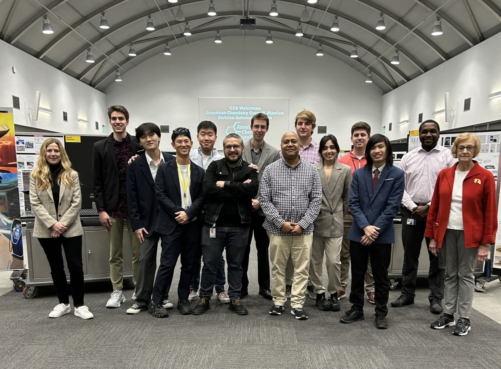 Students standing in a group with representatives from the American Chemistry Council near their models