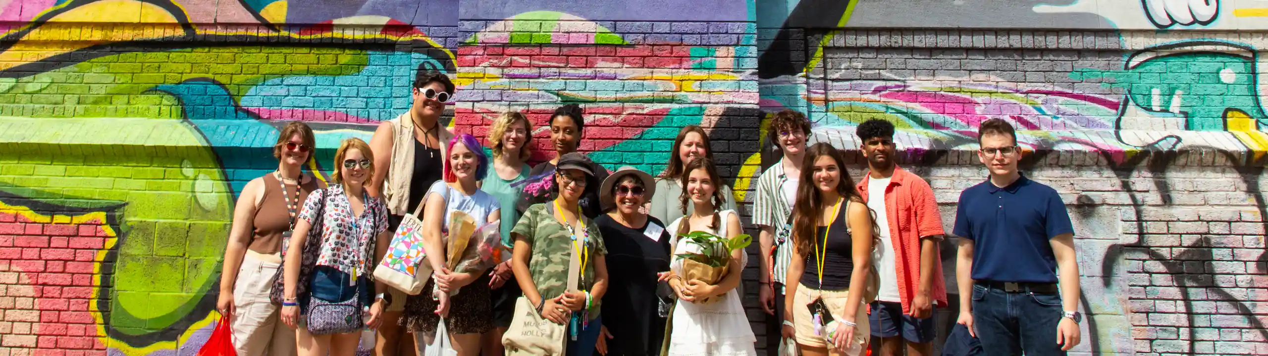 A group of CCS students in front of graffiti.