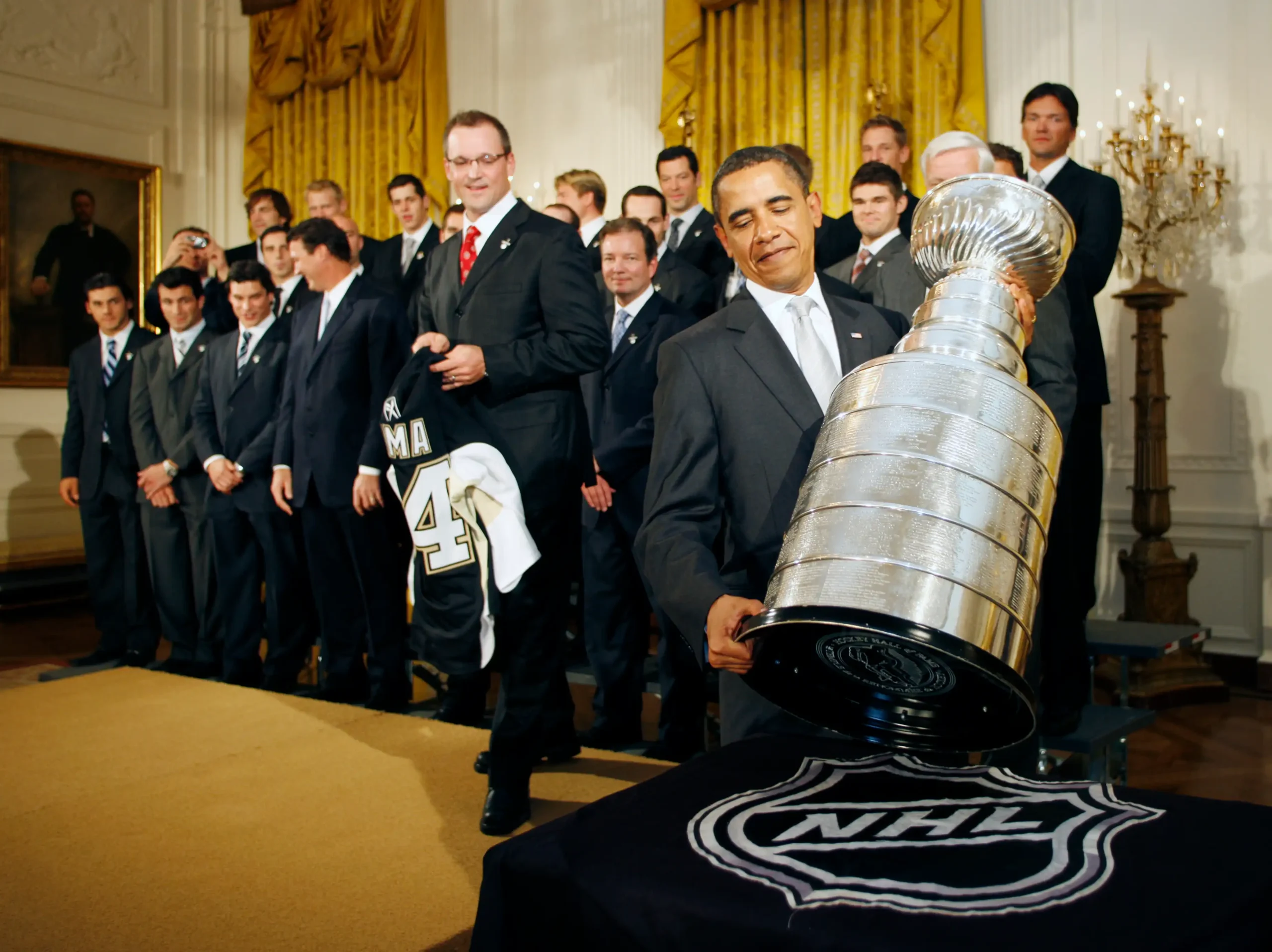 US President Barack Obama holds the Stanley Cup as he poses with the National Hockey League champion Pittsburgh Penguins at the White House in Washington, DC, September 10, 2009.