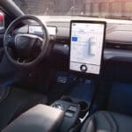 View from inside of a car, showing the wheel and the controls.