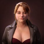 Image of a woman with brown hair, a black jacket, and a red shirt.