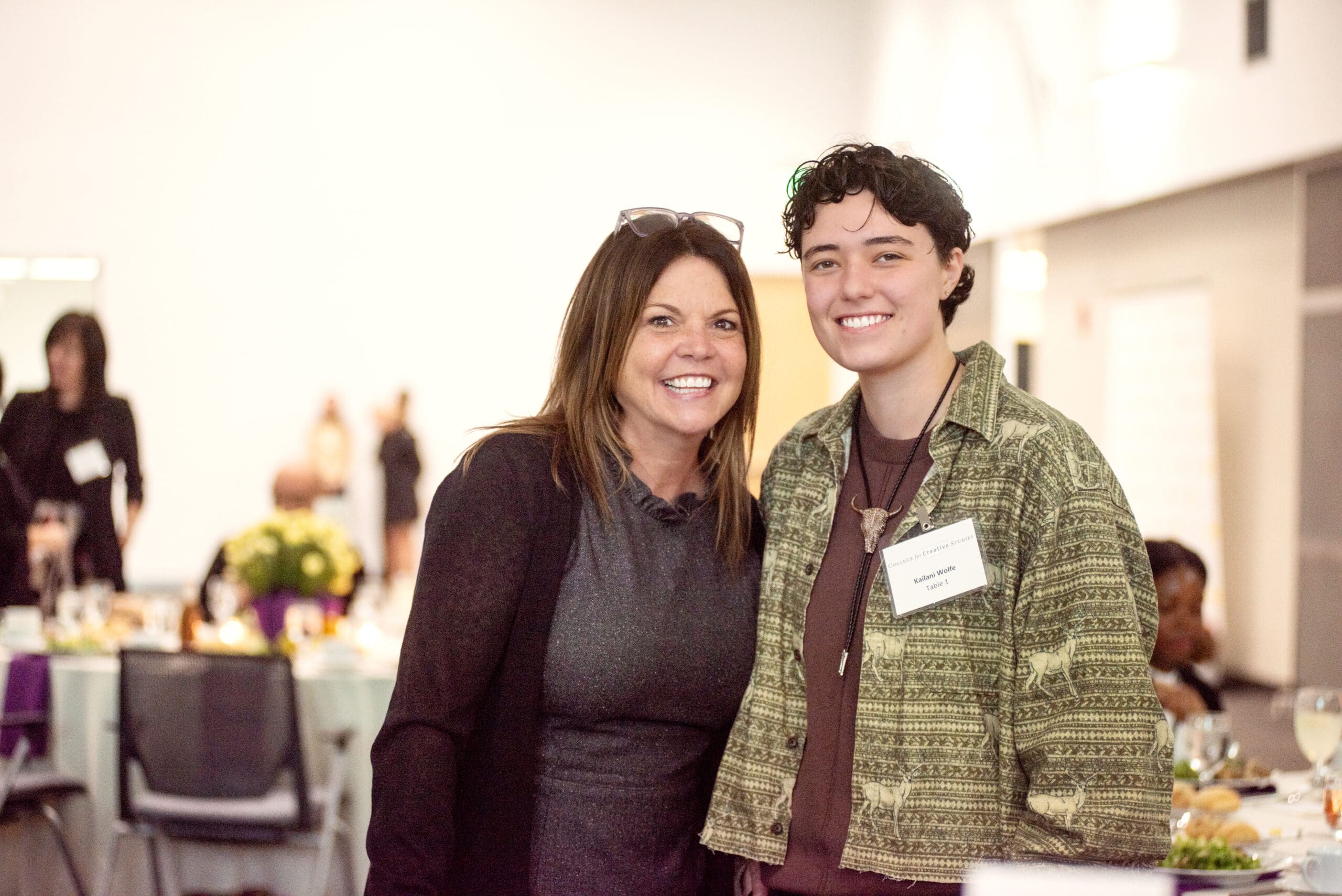 Tracy Muscat stands smiling with student.