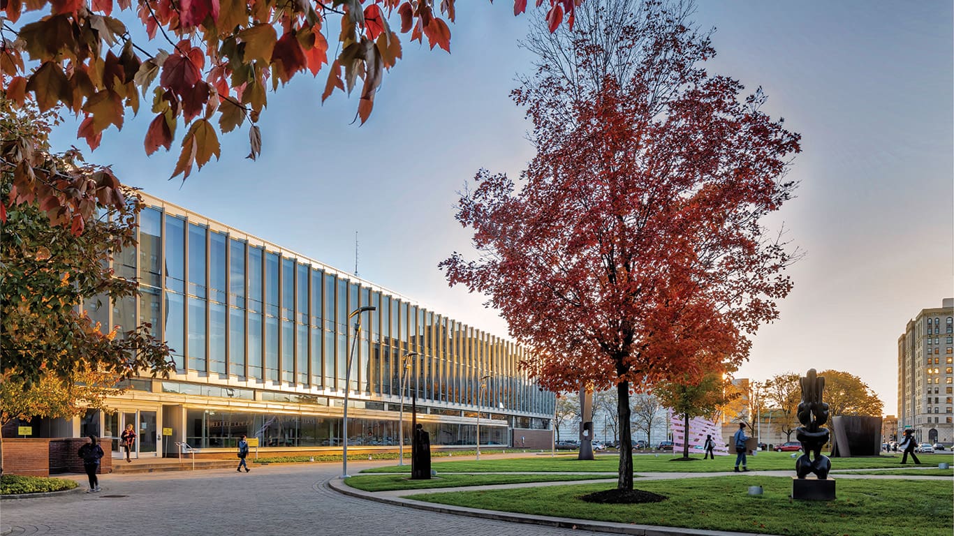 Ford campus during fall. Various students walk the scattered pathways.