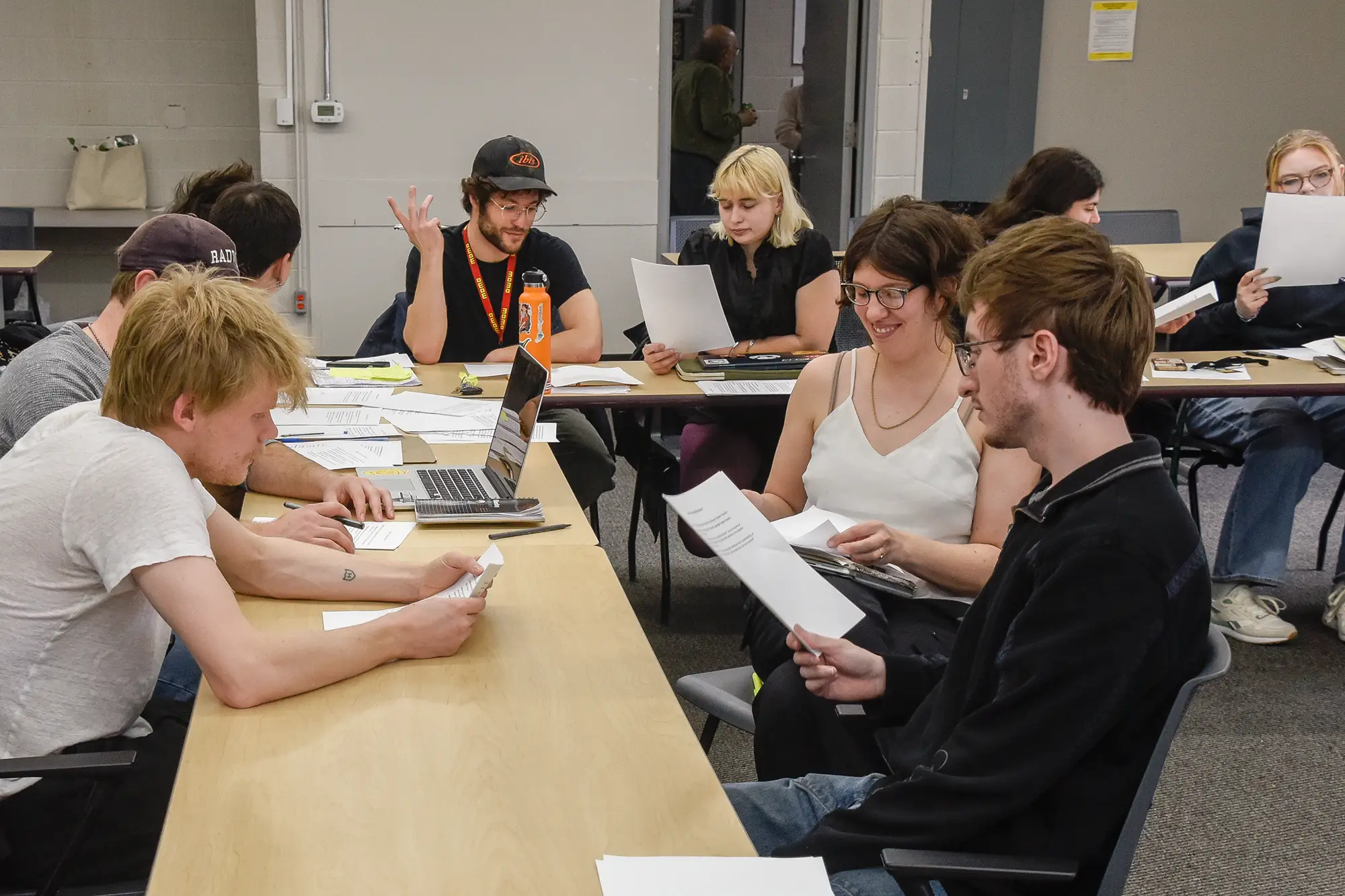 StudentWork-BCI-18 Students work together around a table reading papers and collaborating